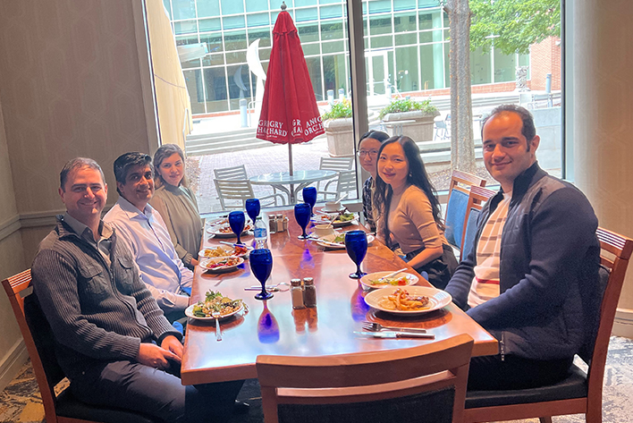 Abhay Kochhar dining with a group of Georgia Tech students and faculty members.